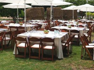 השכרת ריהוט וציוד לאירועים בטבע כיסאות עץ ושולחנות מרובעים עם שמשיות