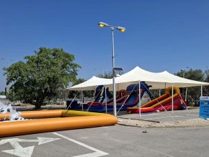 אוהל הצללה לאירועים עם מתקני מתנפחים לילדים בפארק